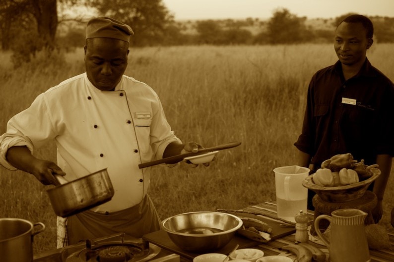 Fredy of Sayari Camp  bereitet die Green Banana Soup vor.